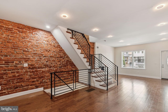 5724 Pine St, Philadelphia, PA 19143 - stairway with brick wall, baseboards, wood finished floors, and recessed lighting