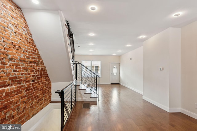 5724 Pine St, Philadelphia, PA 19143 - stairway with brick wall, wood finished floors, recessed lighting, and baseboards