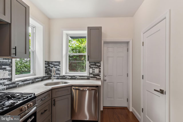 5724 Pine St, Philadelphia, PA 19143 - kitchen featuring stainless steel dishwasher, gray cabinetry, a sink, and decorative backsplash