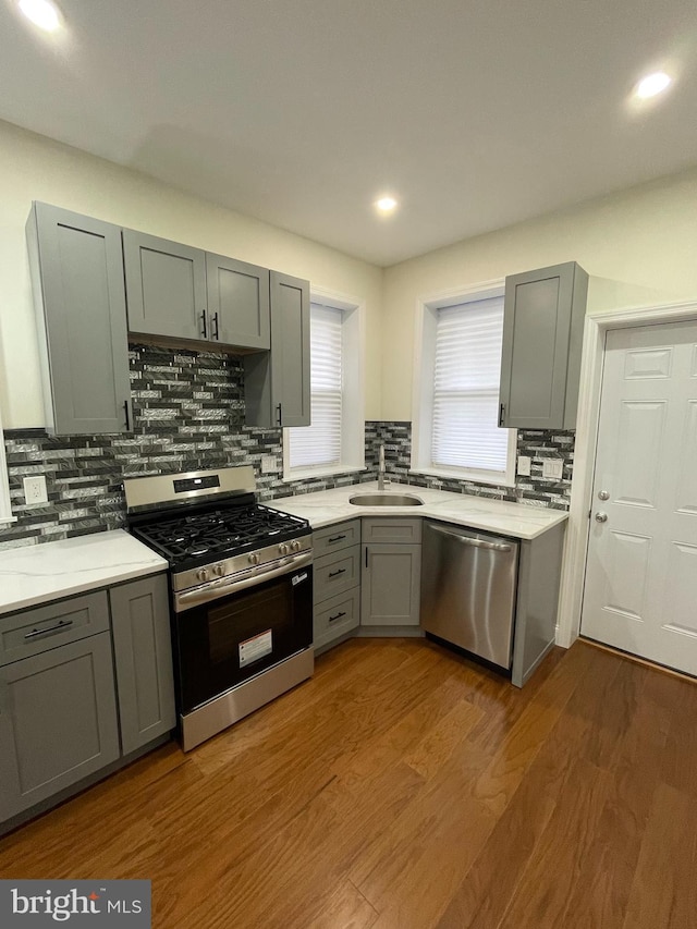 5724 Pine St, Philadelphia, PA 19143 - kitchen featuring stainless steel appliances, gray cabinetry, a sink, backsplash, and light countertops