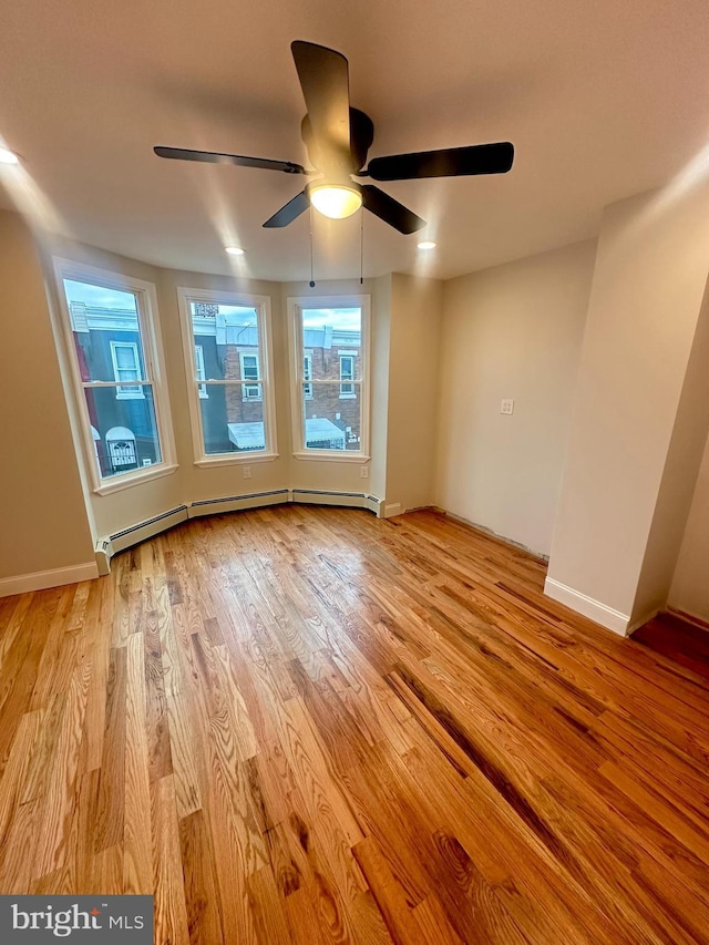 205 W Wishart St, Philadelphia, PA 19133 - empty room featuring a ceiling fan, light wood finished floors, a baseboard heating unit, and baseboards