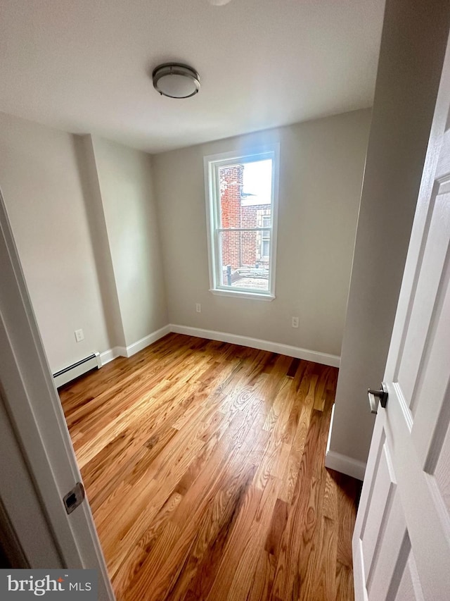 205 W Wishart St, Philadelphia, PA 19133 - empty room featuring a baseboard radiator, light wood-style flooring, and baseboards