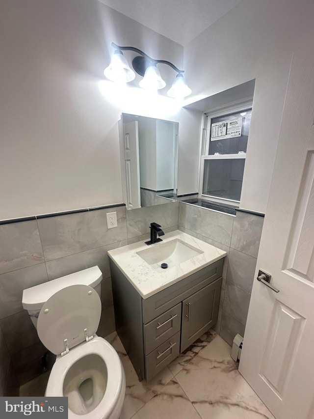 205 W Wishart St, Philadelphia, PA 19133 - bathroom with tile walls, toilet, a baseboard radiator, vanity, and marble finish flooring