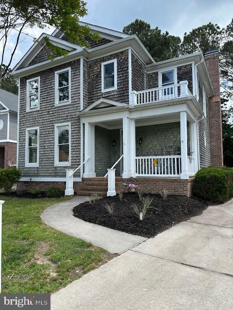 138 Park Side Cir, Ocean Pines, MD 21811 - view of front of home featuring a balcony, covered porch, a chimney, and a front lawn
