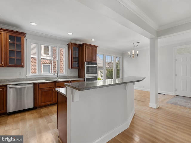 138 Park Side Cir, Ocean Pines, MD 21811 - kitchen with stainless steel appliances, crown molding, a kitchen breakfast bar, a chandelier, and light wood-type flooring
