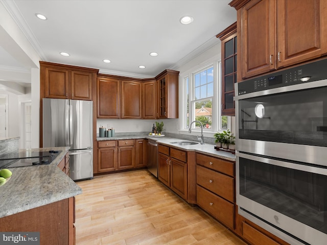 138 Park Side Cir, Ocean Pines, MD 21811 - kitchen featuring appliances with stainless steel finishes, ornamental molding, brown cabinetry, light stone countertops, and light wood-style floors