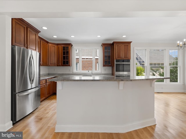 138 Park Side Cir, Ocean Pines, MD 21811 - kitchen featuring stainless steel appliances, a breakfast bar area, light wood-style floors, dark stone counters, and a kitchen island