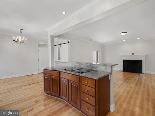 138 Park Side Cir, Ocean Pines, MD 21811 - kitchen featuring black electric cooktop, a barn door, light wood-style floors, a chandelier, and brown cabinetry