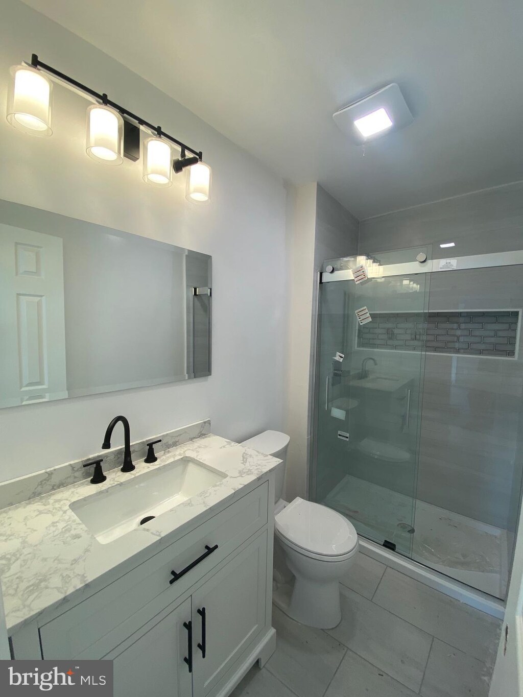 605 Bismark Way, King Of Prussia, PA 19406 - bathroom with vanity, toilet, a stall shower, and marble look tile flooring