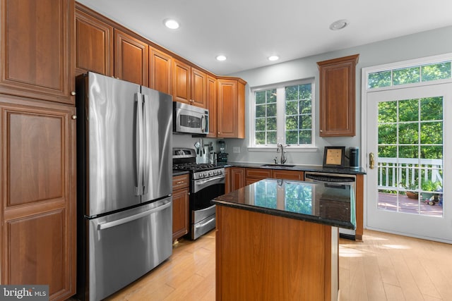 43433 Blair Park Sq, Ashburn, VA 20147 - kitchen with appliances with stainless steel finishes, a sink, dark stone counters, a kitchen island, and light wood finished floors