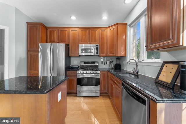 43433 Blair Park Sq, Ashburn, VA 20147 - kitchen with stainless steel appliances, a sink, brown cabinets, recessed lighting, and dark stone counters