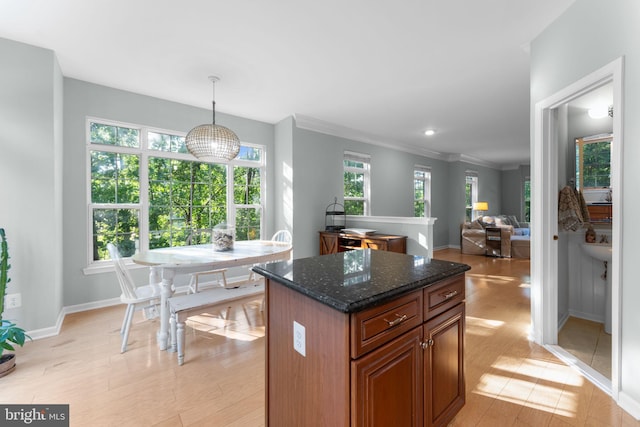 43433 Blair Park Sq, Ashburn, VA 20147 - kitchen featuring light wood-type flooring, healthy amount of natural light, baseboards, a center island, and crown molding