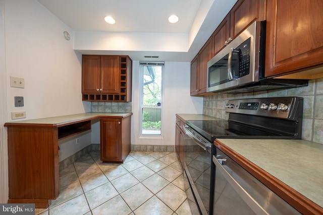 102 W Montgomery Ave Unit A, Ardmore, PA 19003 - kitchen featuring appliances with stainless steel finishes, light tile patterned floors, light countertops, backsplash, and brown cabinetry