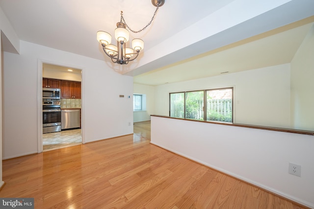 102 W Montgomery Ave Unit A, Ardmore, PA 19003 - empty room with a chandelier, light wood finished floors, and baseboards
