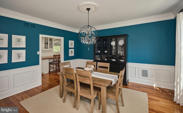 4953 Gloucester Dr, Doylestown, PA 18902 - dining room with a chandelier, crown molding, a wainscoted wall, wood finished floors, and a decorative wall