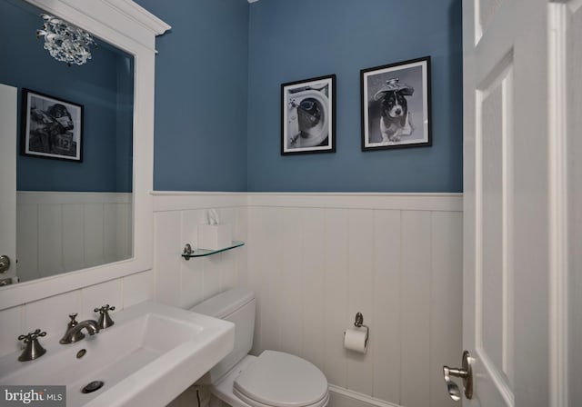 4953 Gloucester Dr, Doylestown, PA 18902 - half bathroom featuring a sink, toilet, and wainscoting