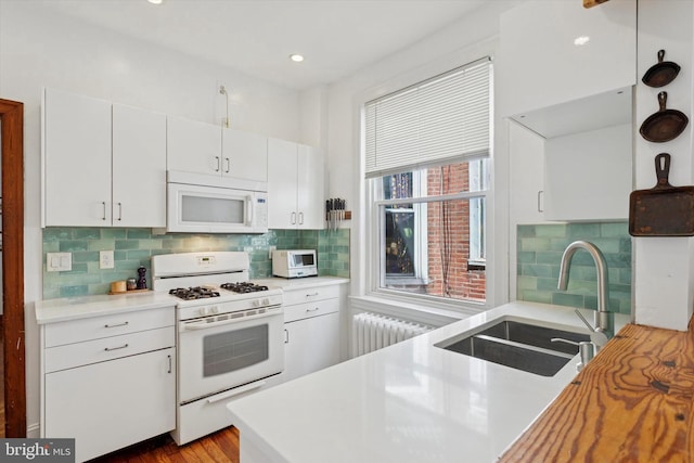527 S 55th St, Philadelphia, PA 19143 - kitchen with white appliances, radiator, a sink, light countertops, and recessed lighting