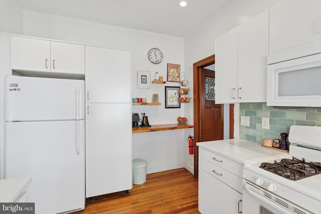 527 S 55th St, Philadelphia, PA 19143 - kitchen featuring white appliances, light countertops, light wood finished floors, backsplash, and white cabinetry