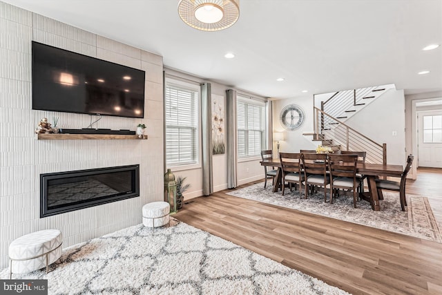 42023 Spring Air Dr, Brambleton, VA 20148 - dining space featuring wood finished floors, baseboards, recessed lighting, stairway, and a large fireplace