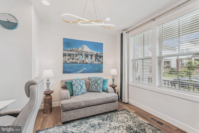 42023 Spring Air Dr, Brambleton, VA 20148 - living room with healthy amount of natural light, a chandelier, and wood finished floors