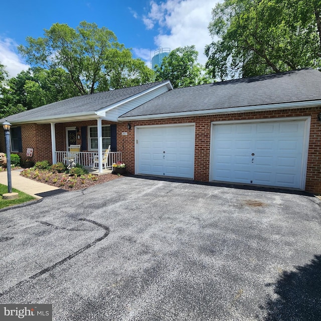 2807 Carlisle Dr Unit 29, New Windsor, MD 21776 - view of front of home featuring an attached garage, asphalt driveway, a porch, and brick siding