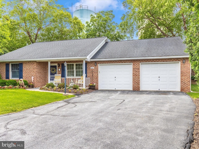 2807 Carlisle Dr Unit 29, New Windsor, MD 21776 - view of front facade featuring a garage, brick siding, asphalt driveway, and covered porch
