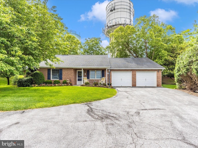2807 Carlisle Dr Unit 29, New Windsor, MD 21776 - view of front of home featuring a garage, asphalt driveway, brick siding, and a front yard