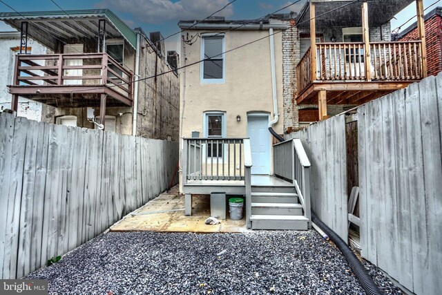 1940 W N Ave, Baltimore, MD 21217 - rear view of house featuring a fenced backyard, a balcony, and stucco siding