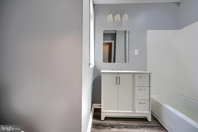 1940 W N Ave, Baltimore, MD 21217 - bathroom with wood finished floors, vanity, and a tub to relax in