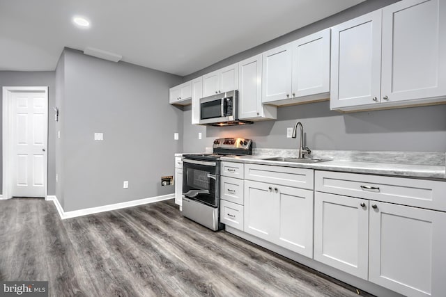 1940 W N Ave, Baltimore, MD 21217 - kitchen with appliances with stainless steel finishes, a sink, light countertops, dark wood finished floors, and white cabinetry