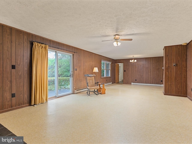 717 W Locust St, Woodstock, VA 22664 - unfurnished room featuring a ceiling fan, light floors, a baseboard radiator, wooden walls, and a chandelier