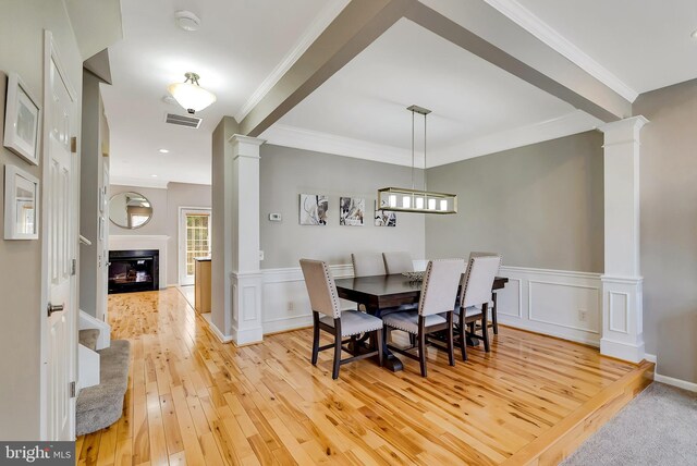 9 Cherry Ct, Lafayette Hill, PA 19444 - dining area featuring decorative columns, light wood finished floors, a glass covered fireplace, ornamental molding, and wainscoting