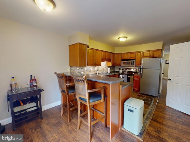 106 Pebble Ln, Bellefonte, PA 16823 - kitchen featuring appliances with stainless steel finishes, dark wood-style flooring, a peninsula, and dark countertops