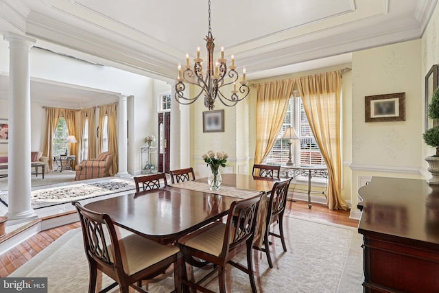 20369 Stillhouse Branch Pl, Sterling, VA 20165 - dining area with ornate columns, ornamental molding, a tray ceiling, light wood-style floors, and a chandelier