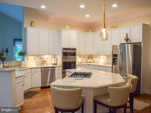 20369 Stillhouse Branch Pl, Sterling, VA 20165 - kitchen with stainless steel appliances, a sink, a kitchen bar, white cabinetry, and backsplash
