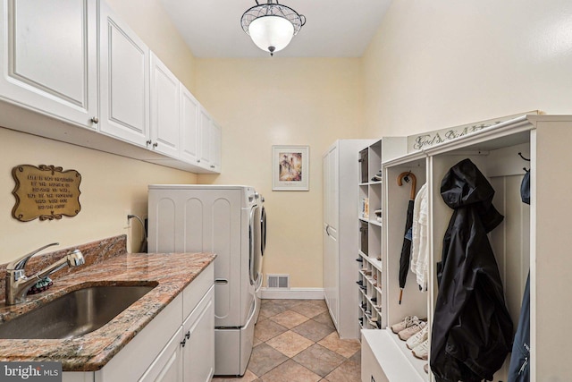 20369 Stillhouse Branch Pl, Sterling, VA 20165 - laundry area with washer and dryer, cabinet space, baseboards, and light stone finish floors