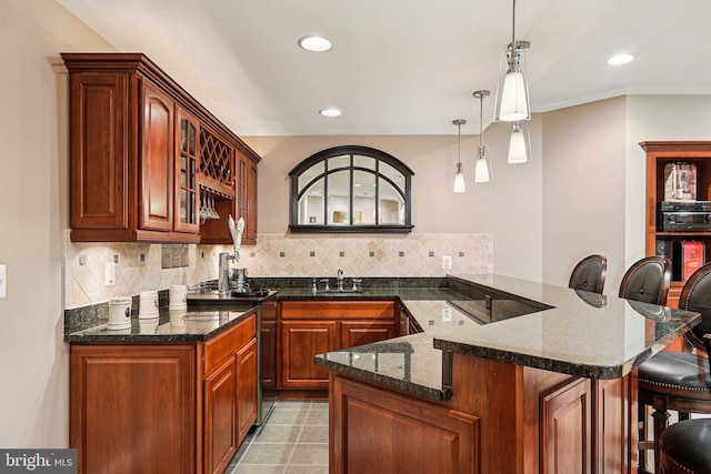 20369 Stillhouse Branch Pl, Sterling, VA 20165 - kitchen featuring a breakfast bar, a peninsula, decorative backsplash, black electric cooktop, and recessed lighting
