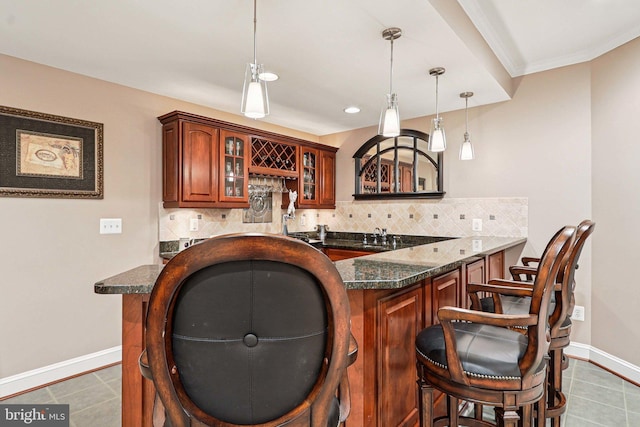 20369 Stillhouse Branch Pl, Sterling, VA 20165 - indoor wet bar featuring tasteful backsplash, baseboards, tile patterned floors, pendant lighting, and ornamental molding