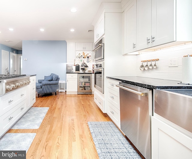 714 Alliance St, Havre De Grace, MD 21078 - kitchen featuring appliances with stainless steel finishes, beverage cooler, white cabinets, dark countertops, and light wood-style flooring