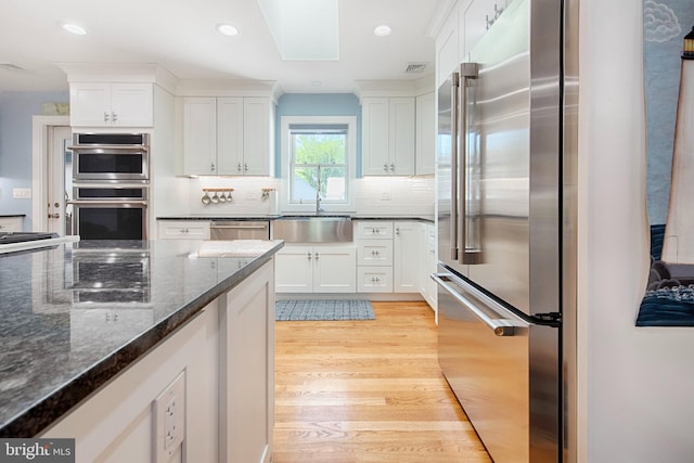 714 Alliance St, Havre De Grace, MD 21078 - kitchen featuring a sink, stainless steel appliances, light wood-type flooring, white cabinetry, and tasteful backsplash