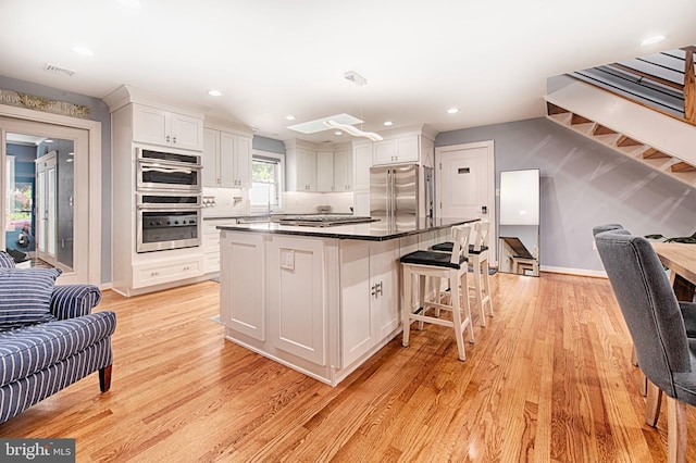 714 Alliance St, Havre De Grace, MD 21078 - kitchen featuring appliances with stainless steel finishes, white cabinets, dark countertops, light wood finished floors, and recessed lighting