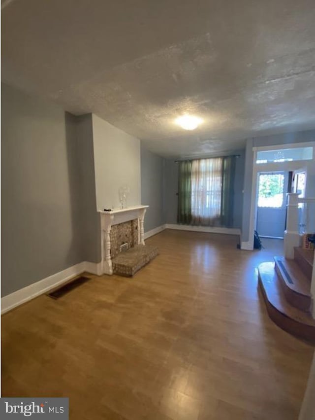 4216 Wyalusing Ave, Philadelphia, PA 19104 - unfurnished living room featuring baseboards, wood finished floors, and a fireplace