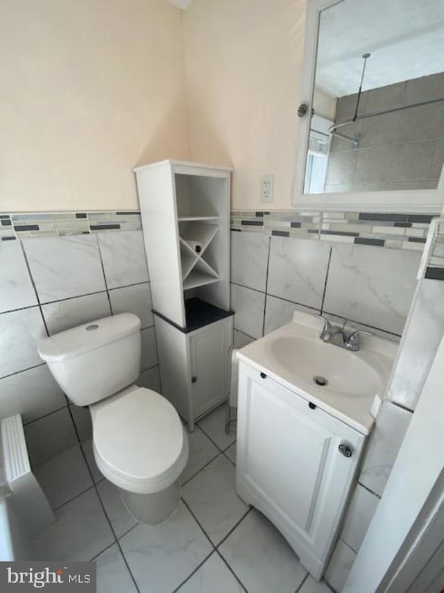 4216 Wyalusing Ave, Philadelphia, PA 19104 - bathroom with tile walls, vanity, toilet, marble look tile flooring, and wainscoting