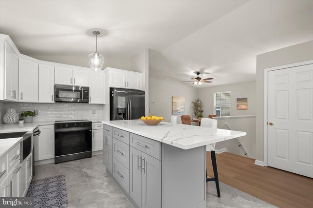 808 Pasadena Ave, Severna Park, MD 21146 - kitchen with appliances with stainless steel finishes, a kitchen bar, decorative backsplash, lofted ceiling, and ceiling fan