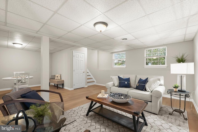 808 Pasadena Ave, Severna Park, MD 21146 - living area with wood finished floors, a paneled ceiling, stairs, and baseboards
