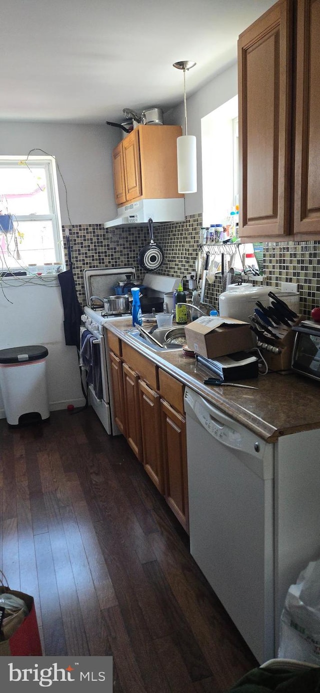 1447 S Chadwick St, Philadelphia, PA 19146 - kitchen with white appliances, dark wood finished floors, tasteful backsplash, dark countertops, and hanging light fixtures