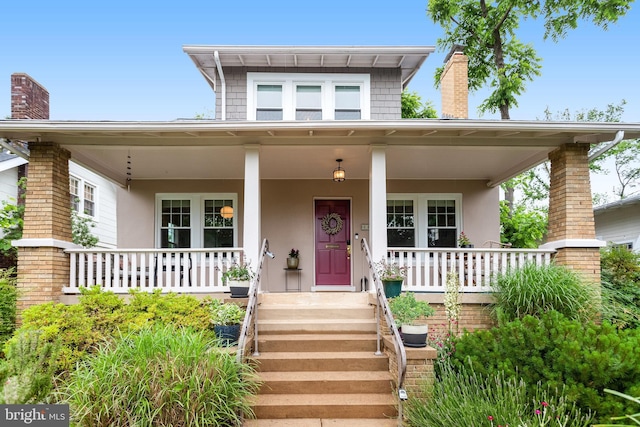 815 Aspen St NW, Washington, DC 20012 - view of front of house featuring a chimney, stucco siding, and a porch