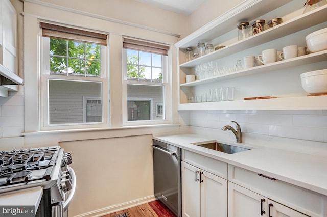 815 Aspen St NW, Washington, DC 20012 - kitchen featuring appliances with stainless steel finishes, open shelves, tasteful backsplash, a sink, and wood finished floors