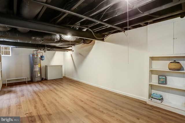 815 Aspen St NW, Washington, DC 20012 - unfinished below grade area featuring electric water heater, wood finished floors, and baseboards