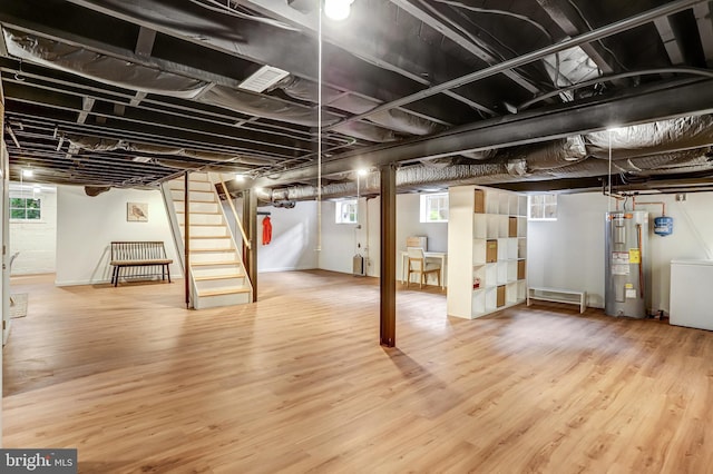 815 Aspen St NW, Washington, DC 20012 - below grade area with electric water heater, stairway, wood finished floors, and washer / dryer